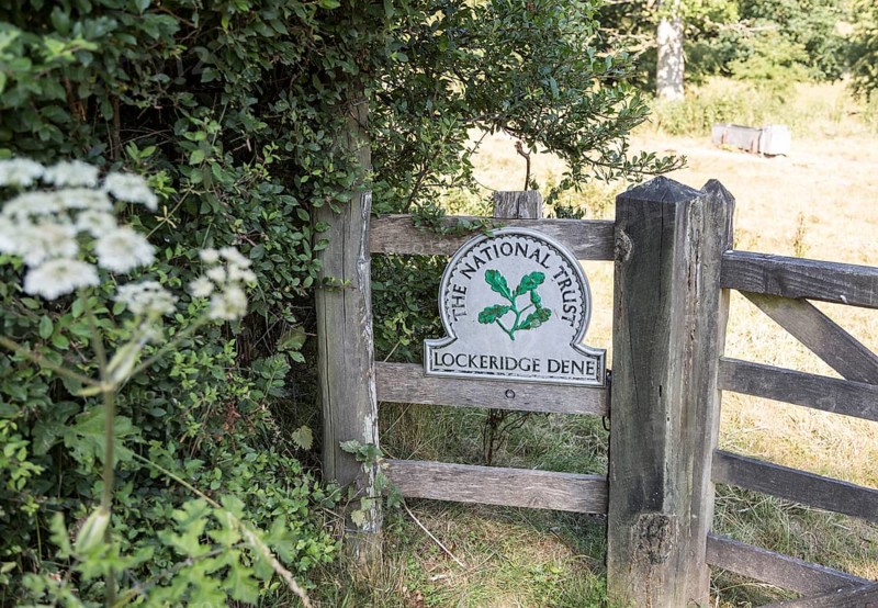National Trust sign at an entrance to Lockeridge Dene, near Marlborough, Wiltshire, England, UK