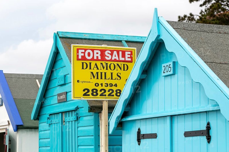 Estate agent for sale sign on seaside beach hut building, Felixstowe, Suffolk, England, UK