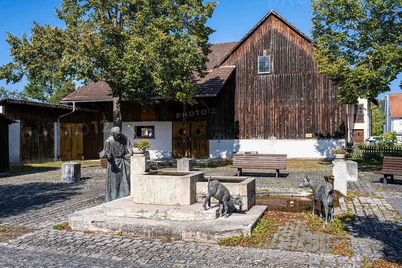 Town fountain with bronze sculptures by a stonemason and domestic goats in the town centre and old town of Aach im Hegau, district of Constance, Baden-Württemberg, Germany, Europe