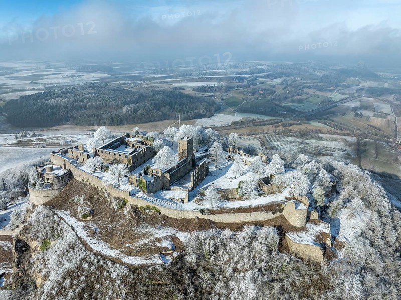 Aerial view of the snow-covered Hegau volcano Hohentwiel with Germany's largest castle ruins, surrounded by frosty trees in a winter landscape, district of Constance, Baden-Württemberg, Germany, Europe