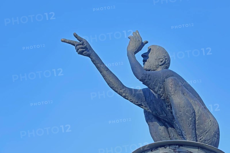 Sculpture The Scout by Karl Ulrich Nuss 2019, bronze sculpture, male figure, sitting, squatting, crouching, gesture, gesture, arms, arm, index finger, finger, hand, see, look, look, view, free-standing, castle park, Essingen, Swabian Alb, Baden-Württemberg, Germany, Europe