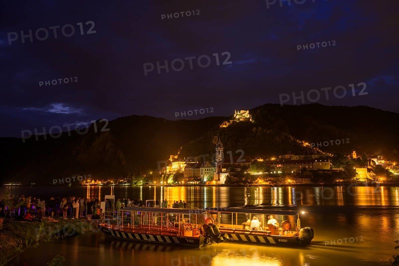 People and bicycle ferry from Rossatz and behind Dürnstein in front of the fireworks for the solstice, Rossatz-Arnsdorf, Lower Austria, Austria, Europe