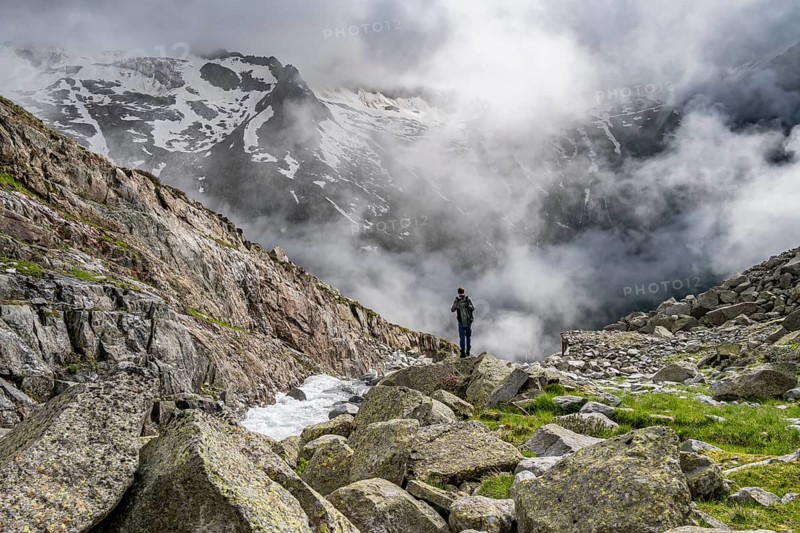 Mountaineer at a mountain stream, Furtschaglbach, cloudy mountains in the background, Furtschaglhaus, Berliner Höhenweg, Zillertal, Tyrol, Austria, Europe