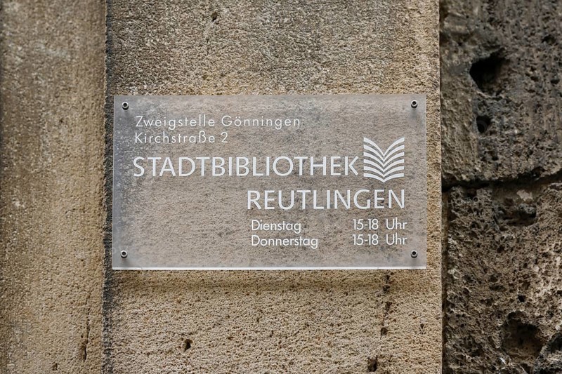 Sign on the old schoolhouse, building from 1867 made of Gönningen tuff, former elementary and secondary school, today Gönningen town library branch, Gönningen, Reutlingen district, Baden-Württemberg, Germany, Europe