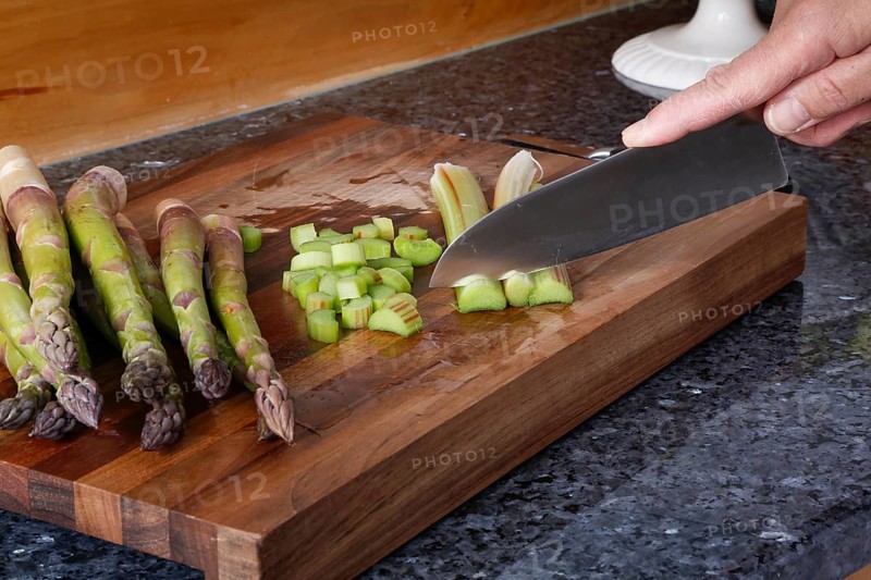 South German cuisine, vegetables, vegetarian, preparation of green asparagus with rhubarb vinaigrette and potato gratin, healthy, raw asparagus on wooden board, cutting board, cutting rhubarb, traditional cuisine reinterpreted, man's hand, knife, food photography, studio, Germany, Europe