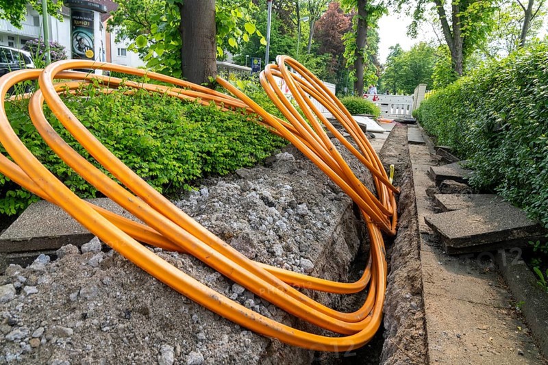 Laying of fibre optic cables, empty conduits are laid under a pavement, in which the actual fibre optic cable is later blown in and connected to the respective house connection or distributor. Essen, North Rhine-Westphalia, Germany, Europe