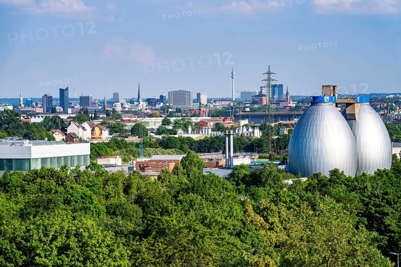 View of Dortmund city centre from the Deusenberg spoil tip, with the digestion towers of the Deusen Emscher sewage treatment plant in the foreground, North Rhine-Westphalia, Germany, Europe