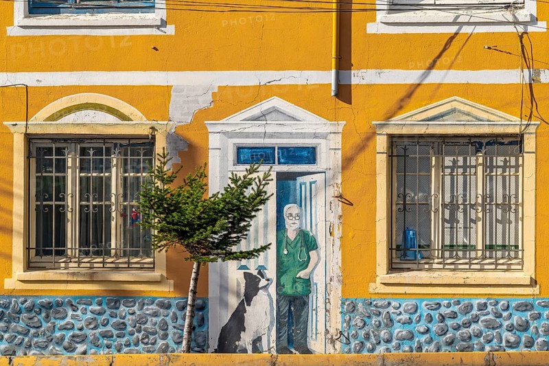 Facade art with optical illusion shows a man with a dog in his front door, city of Punta Arenas, Patagonia, Chile, South America