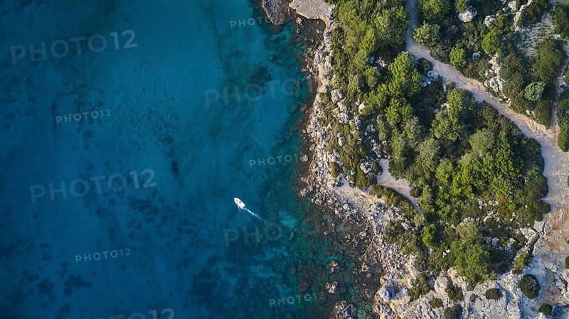 Drone shot, Clear blue water along a coast with dense vegetation, a small boat, Anthony Quinn Bay, Vagies Bay, Rhodes, Dodecanese, Greek Islands, Greece, Europe