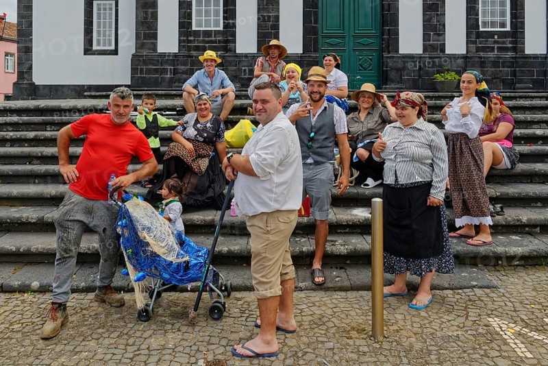 Group of cheerful people in traditional dress posing on a staircase, Fenais da Luz, Sao Miguel Island, Azores, Portugal, Europe