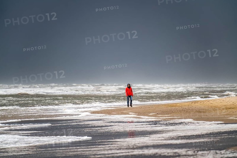 Walkers on the beach, dark storm clouds, choppy sea, autumn on the North Sea in North Holland, between the towns of Egmond aan Zee and Bergen aan Zee, Netherlands