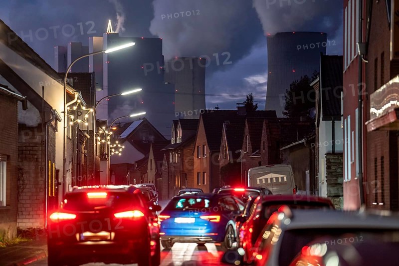 The village of Vanikum, part of the municipality of Rommerskirchen, main street, behind it the Neurath lignite-fired power plant, near Grevenbroich, thick water vapour cloud from the cooling towers in winter, near Grevenbroich, will continue to run until 2024 to secure energy supplies, North Rhine-Westphalia, Germany, Europe