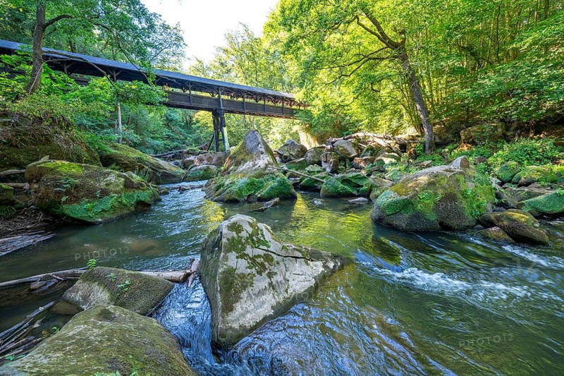 The Irrel Waterfalls, rapids in the lower reaches of the Prüm, covered wooden bridge for hikers, between Prümzurlay and Irrel, in the Eifel district of Bitburg-Prüm, Rhineland-Palatinate. Germany