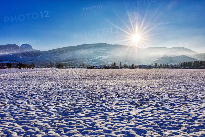 Snowy winter landscape in the morning sunshine with mountain views, Bad Feilnbach