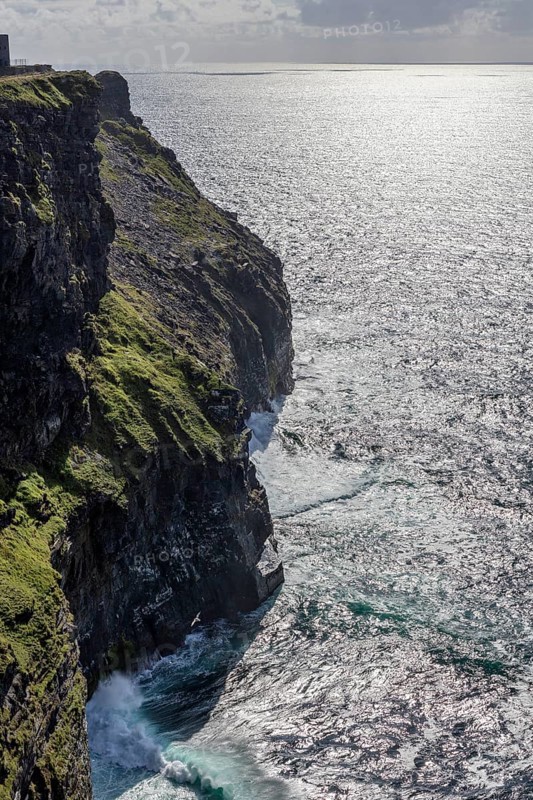 Sunbeams are reflected in the sea along the green cliffs that plunge into the depths, Cliffs of Moher