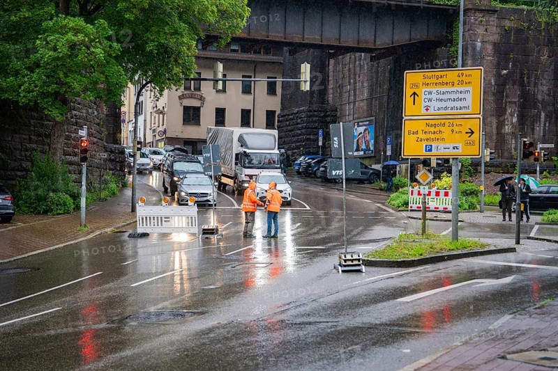 Road closure due to construction site in the city during rain, workers and traffic signs visible, construction site Hermann Hesse railway, Calw, Black Forest, Germany, Europe