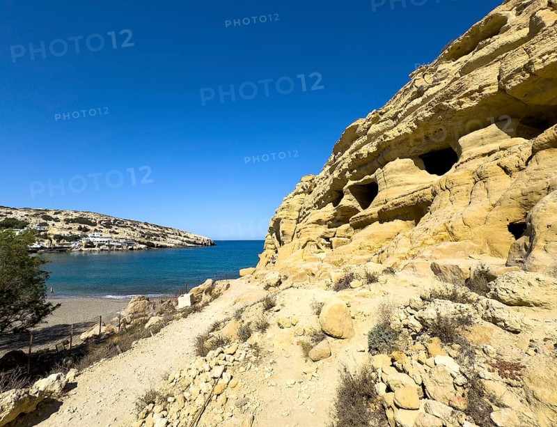 View of partial view of former Roman necropolis with sandstone caves carved into sandstone Cave tombs Grottoes in rocks on the north side of Matala Bay, in the 60s and 70s hippie caves Caves for dropouts and hippies today excursion destination on the south coast of the island of Crete, left at the edge of the picture Libyan Sea Mediterranean Sea, Matala, Crete, Greece, Europe