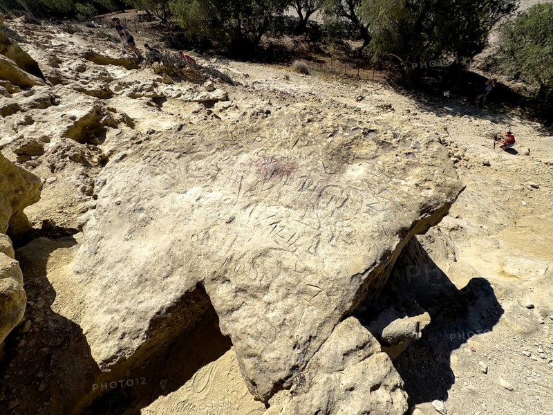 Graffiti of hippies dropouts visitors tourists in sandstone on wall in front of former Roman necropolis on north side of bay of Matala, in 60s and 70s hippie caves caves living caves for dropouts and hippies today excursion destination on south coast of island of Crete, Matala, Crete, Greece, Europe