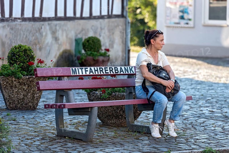 Carpooling bench, carpooling bench, public bench for private carpooling, rural, young woman waiting for a lift, organised hitchhiking, hitchhiking, Florstadt, Wetterau, Hesse, Germany, Europe