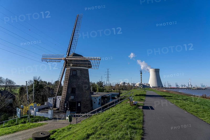 The Doel nuclear power plant on the Scheldt, one of two nuclear power plants in Belgium, consists of three operating units, each with a pressurised water reactor, as well as a decommissioned unit, historic Scheldemolen, windmill on the Scheldt dike, Antwerp, Belgium, Europe