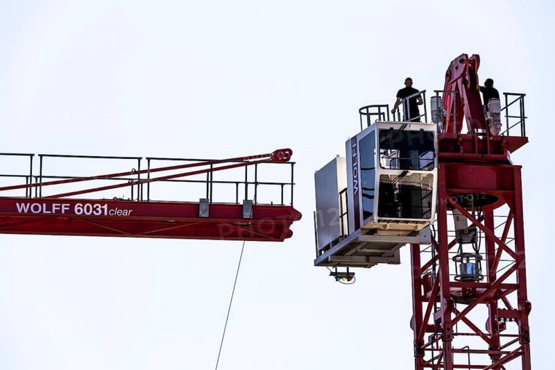 Erection of a construction crane, part of the upper crane section is hoisted by mobile crane onto an already assembled section