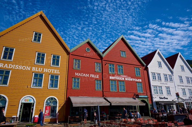 Traditional wooden houses under a blue sky with pitched roofs and multiple windows in a sunny old town, Bryggen, Bergen, Vestland, Norway, Europe