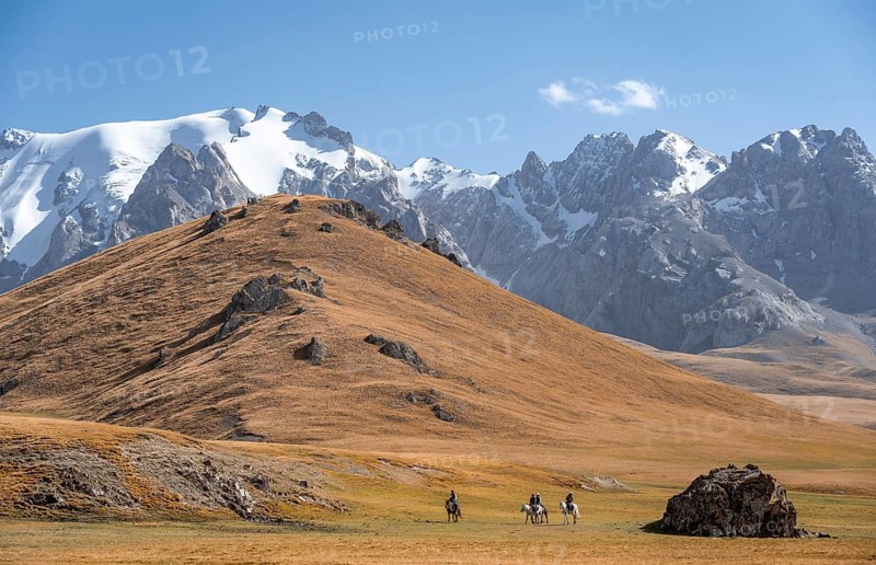 Rider in front of mountain landscape with yellow meadows, mountain peak, Keltan Mountains, Sary Beles Mountains, Tien Shan, Naryn Province, Kyrgyzstan, Asia