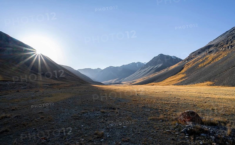 Mountain valley at sunrise, sun star, barren landscape, Burkhan valley, Tien Shan, Issyk Kul province, Kyrgyzstan, Asia