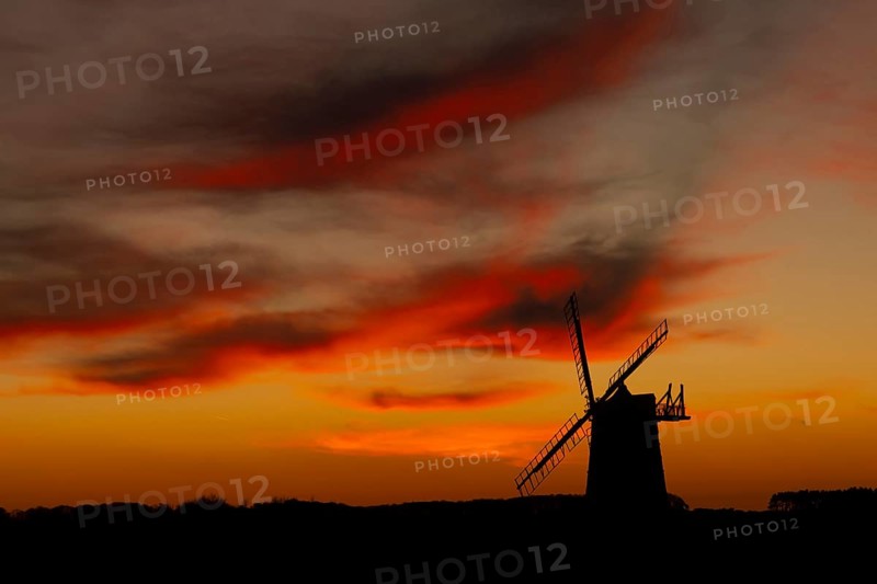Windmill silhouette at sunset with a red sky and clouds, Burnham Ovary Staithe, Norfolk, England, United Kingdom, Europe