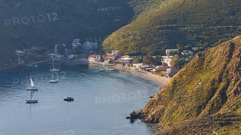 A picturesque coastal village with boats on a sunny evening, surrounded by mountains, southern tip, Mani Peninsula, Peloponnese, Greece, Europe