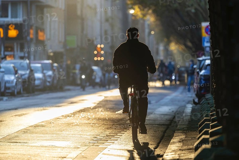 Cyclists in oblique sunlight in November, poor visibility, danger of glare, cycle lane, cyclists have priority over motor traffic, Cologne, North Rhine-Westphalia, Germany, Europe