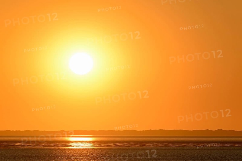 Sunset over the North Sea at low tide, the outline of the island of Juist on the horizon, Norddeich, Lower Saxony, Germany, Europe