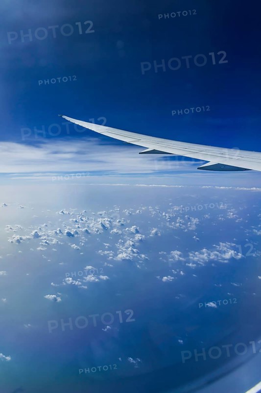 Blue sky, cloud structures over the Arabian Sea. View from the aircraft window during a flight from Phuket to Abu Dhabi with the airline Etihad. Wing of a Boeing 787 aircraft. Abu Dhabi, United Arab Emirates, UAE, Southwest Asia, Asia