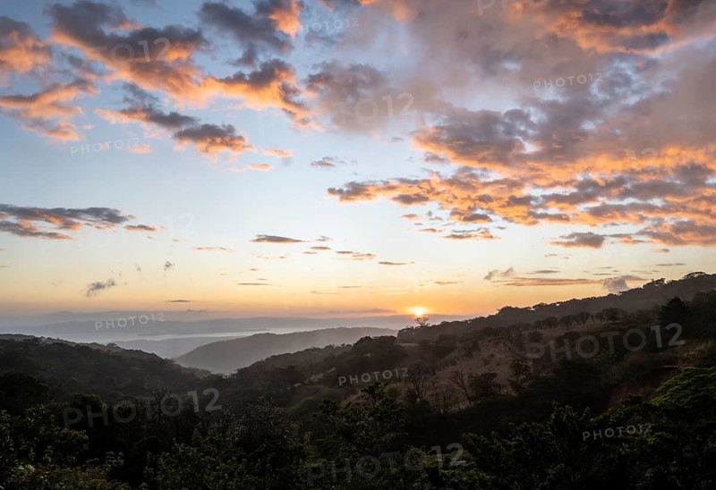 View to the sea over wooded hills, at sunset, cloud forest, Monte Verde, Puntarenas province, Costa Rica, Central America