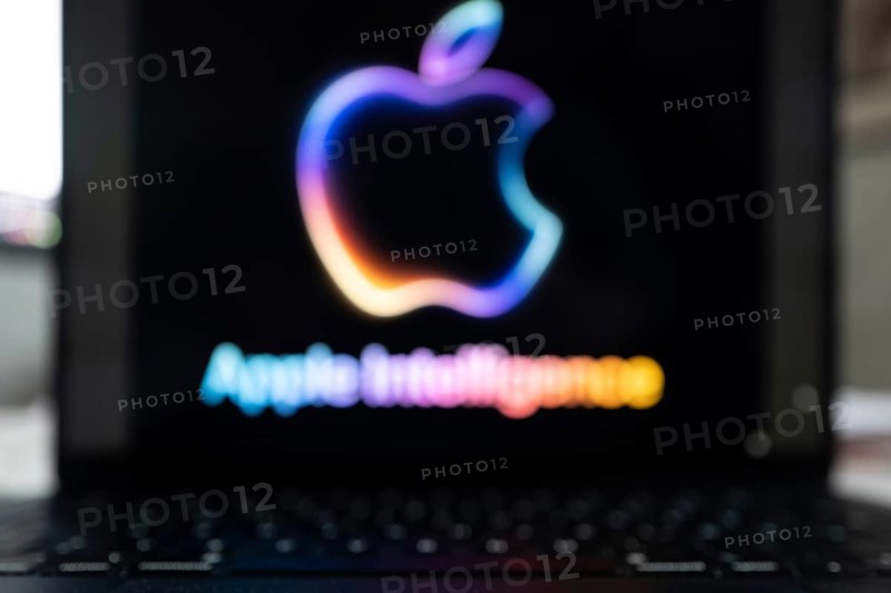 Blurred Apple Intelligence logo in bright neon colours on a Macbook with illuminated keyboard, symbolic image of artificial intelligence