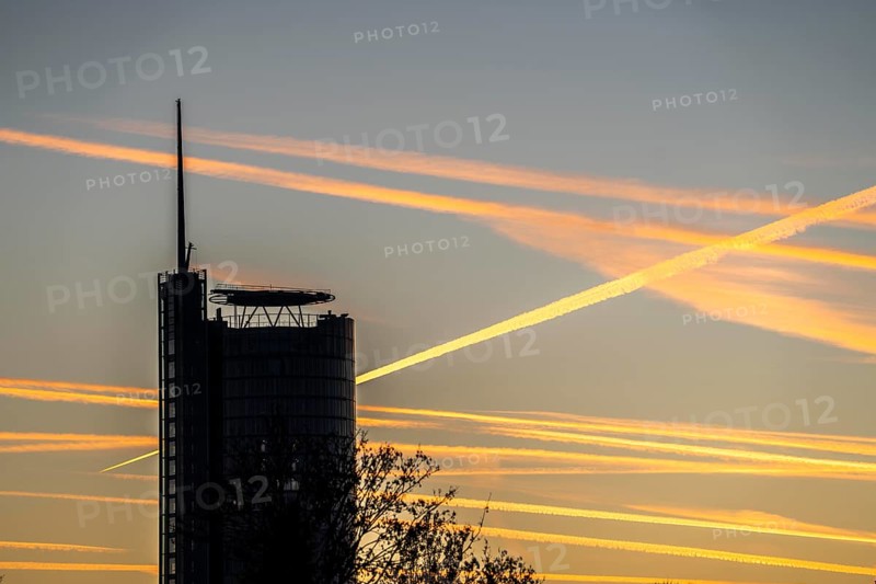 Condensation trails from aircraft flying at high altitude, evening sky, after sunset