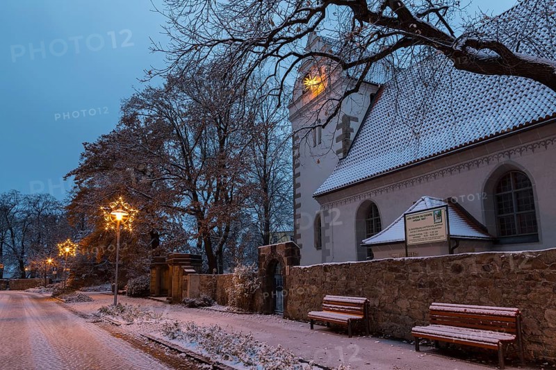 Old church with illuminated poinsettia, snowy and at dusk, Coswig, Saxony, Germany, Europe