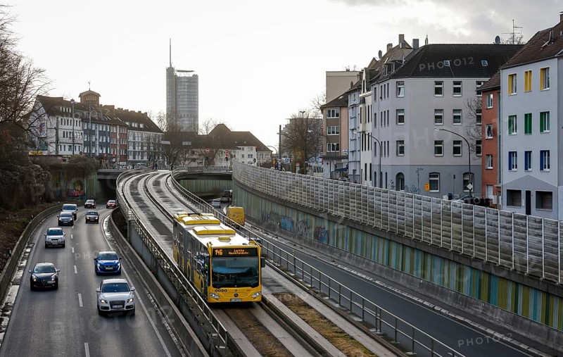 Essen, North Rhine-Westphalia, Germany - Cars and a public bus drive on the A40 motorway through the city centre of Essen, behind the Westenergie Tower, former RWE Tower