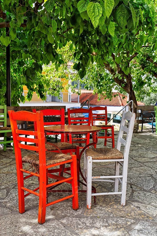 Terrace under trees, table and red chairs in front of a café, small town Leonidio, Tsakonia, Arcadia, Peloponnese, Greece, Europe