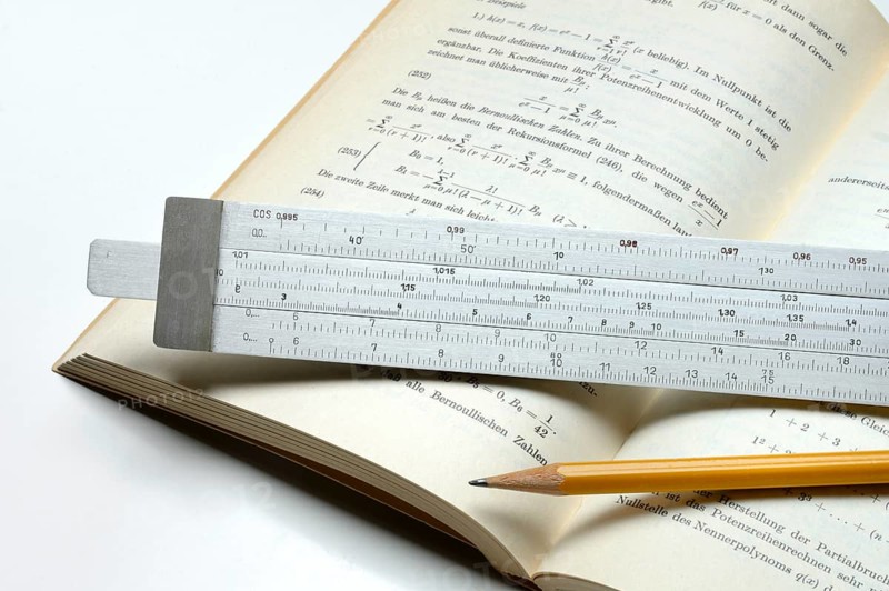 Slide rule on book, calculating aid