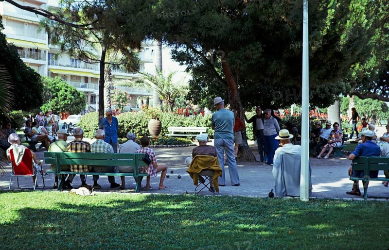 Men playing a game of boules in the shade of trees in a public park, Antibes, Côte d'Azur, France 1974