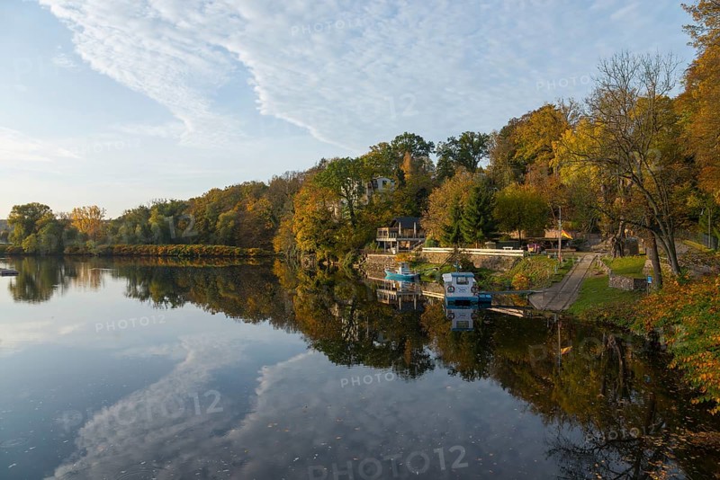 Idyllic river landscape in autumn with trees, boats and reflections in the water, River Mulde, Grimma, Leipzig, Saxony, Germany, Europe