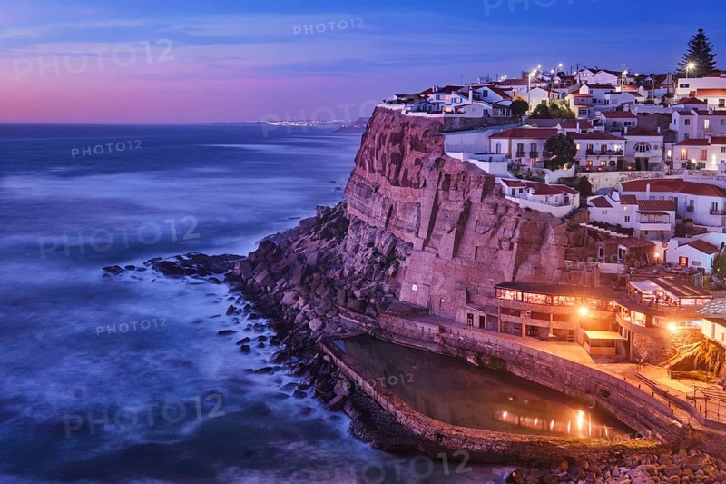 Scenic view of the seaside Azenhas do Mar fishing village on cliff on Atlantic ocean coast, Portugal in evening twilight dusk