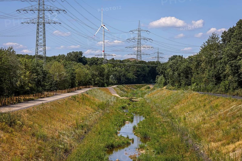 Bottrop, North Rhine-Westphalia, Germany, Renaturalised Boye, the tributary of the Emscher, has been transformed into a near-natural watercourse, flood protection through newly designed flooding areas, the Boye is now free of wastewater following the construction of a parallel sewer, is part of the Emscher river system and thus part of the Emscher conversion, was previously an open, above-ground wastewater channel, mixed water channel with surface water and wastewater. Wind turbine on the Mottbruch spoil tip at the back, Europe
