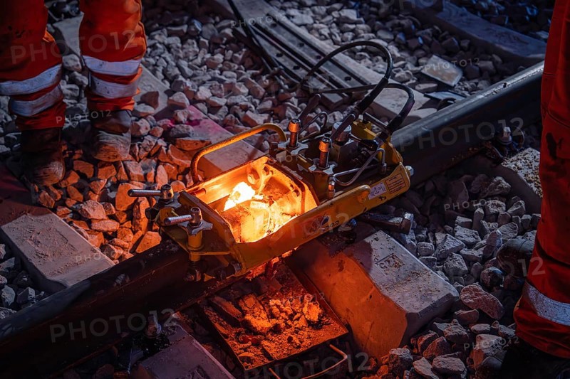 Worker during night-time track work with welding equipment and red-hot melting point on the rails, rail welding, track construction Hermann Hessebahn, Calw, Black Forest, Germany, Europe