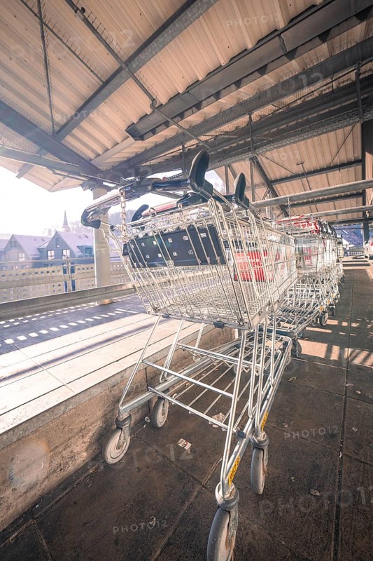 Row of shopping trolleys under a covered area with sunbeams, Kaufland Calw multi-storey car park, Calw district, Black Forest, Germany, Europe