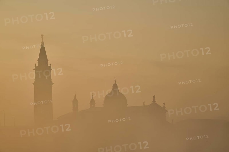 View from 'Colonna di San Marco e San Teodoro' on church 'Giorgio Maggiore' on a foggy morning at sunrise in Venice in winter, Italy, Europe