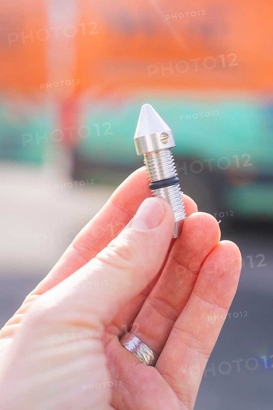 Hand holding a small metal component in front of a blurred background, Wend Glasfasermontage during the jetting of conduits for fibre optic cables, Meßkirch, district of Sigmaringen, Germany, Europe