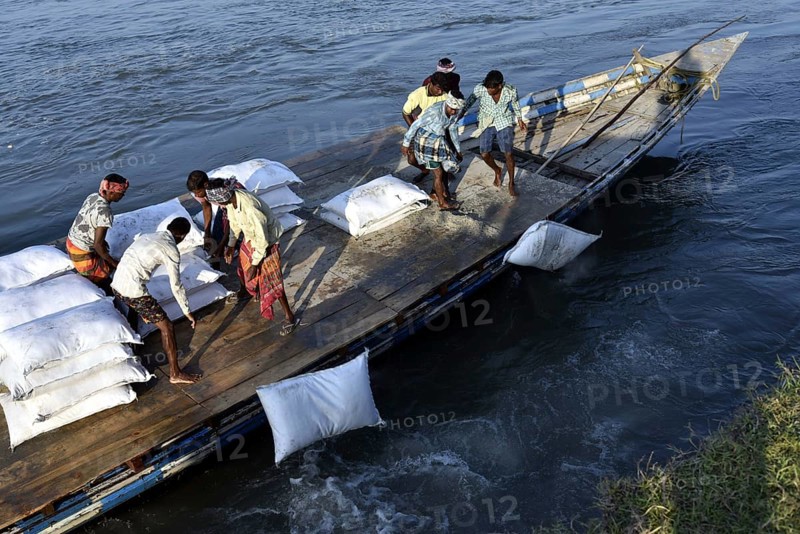 Public Works Department (PWD) of Assam labourer throwing sand bag from boat in the banks of Beki River to reduce soil erosion in Barpeta, Assam in India on Tuesday, November 13, 2018. The soil erosion of Beki river has become a major problem of flowing two districts Barpeta and Baksa of Assam