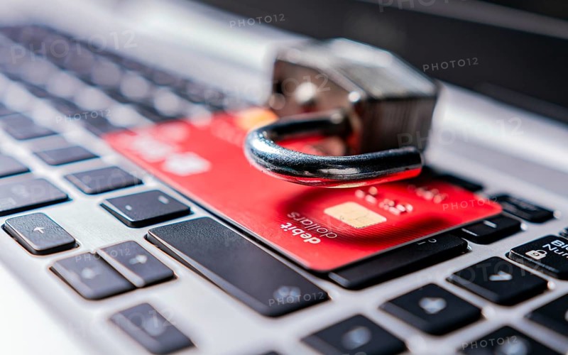Padlock on top of credit card on laptop keyboard. Open padlock with credit card on keyboard. Concept of theft of information on credit cards